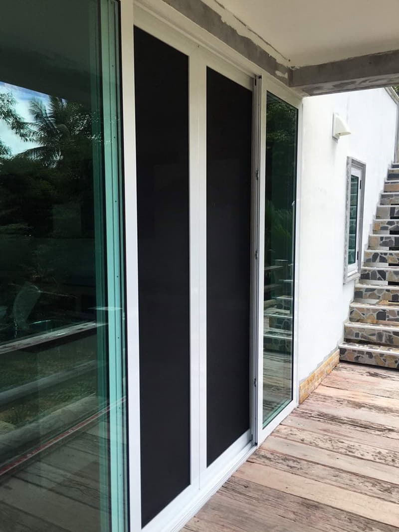White aluminium combined glass and security screen doors installed at a Phuket home