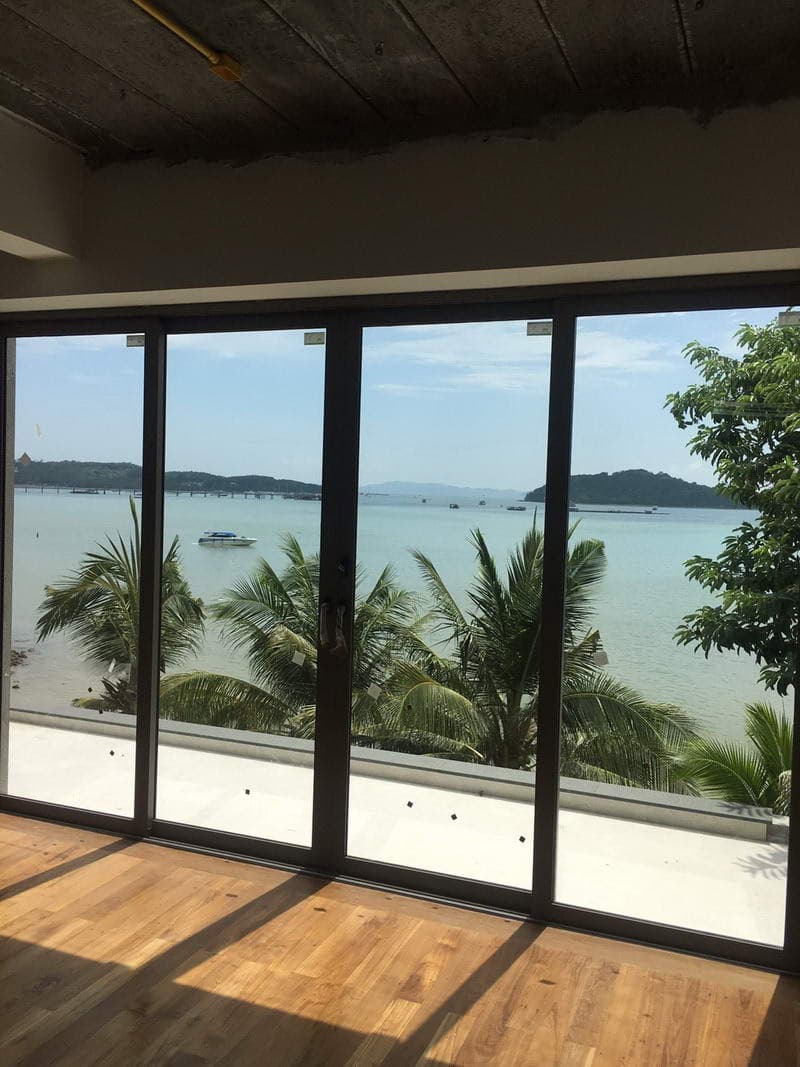 Pailin Smiley aluminium glass doors framing the sea and palm trees in Phuket