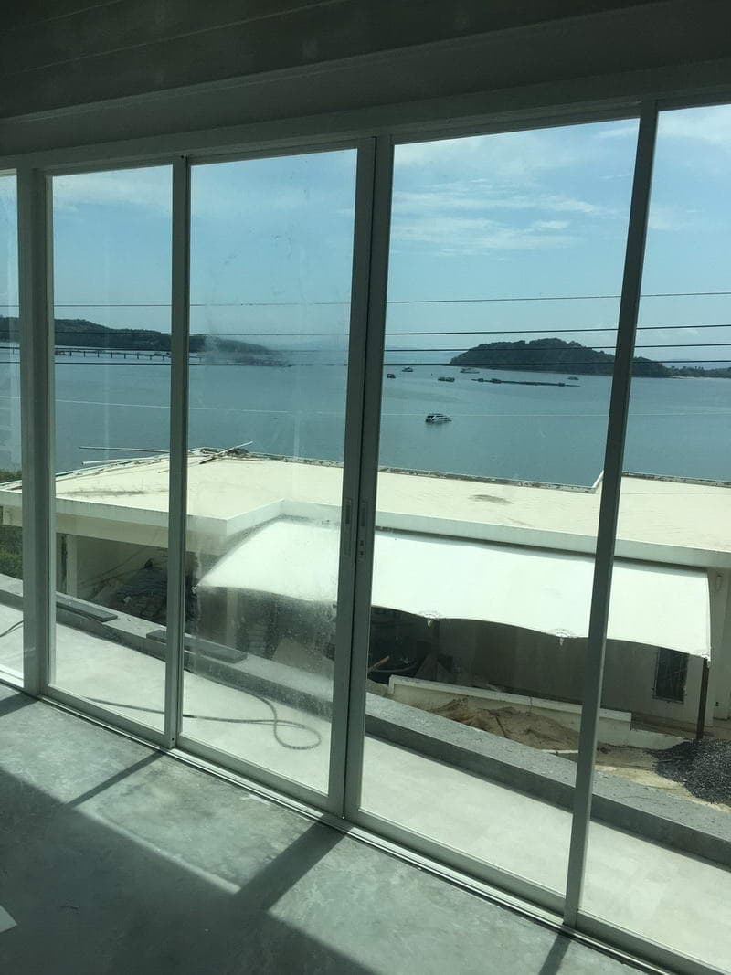 Full-height glass doors overlooking the Andaman Sea